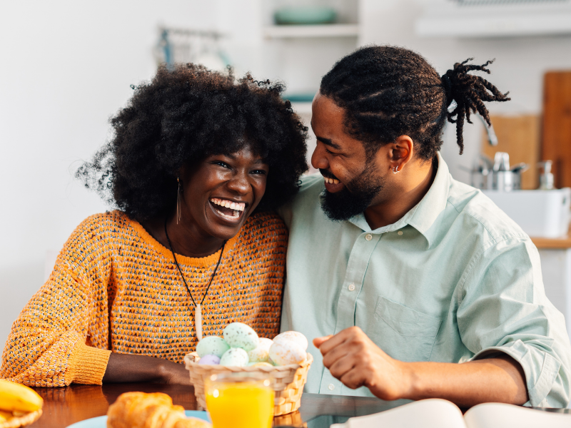 A couple laughing together over breakfast at home